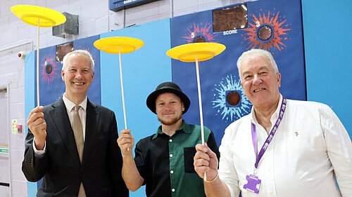 Gideon Amos MP and Cllr Rob Isaacs have a go at plate spinning with Scott Dowson from Fuse Performance and Somerset Outdoor Arts Circus Workshop. Rob Isaacs WMIS